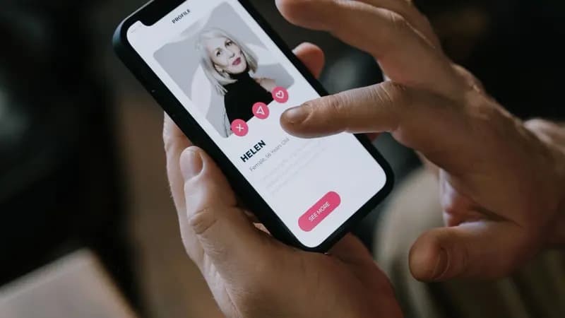 Hands holding a phone showing a dating app