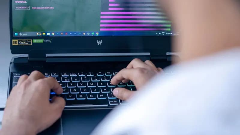 Person typing on a laptop with an AI chatbot open