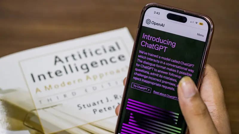 Person holding a phone showing the ChatGPT introduction screen