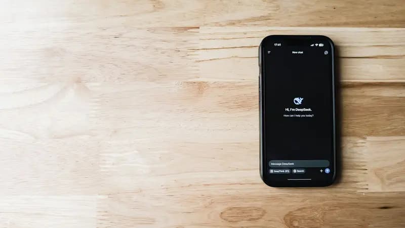 A smartphone showing an AI assistant app on a wooden surface