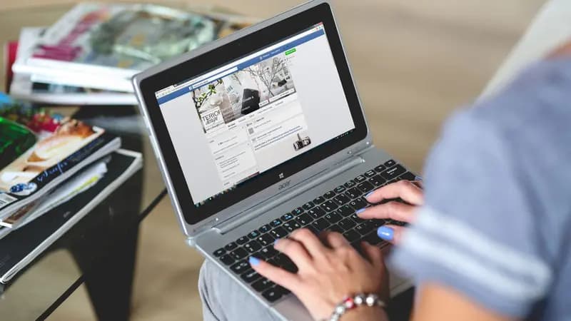 Hands typing on a laptop keyboard