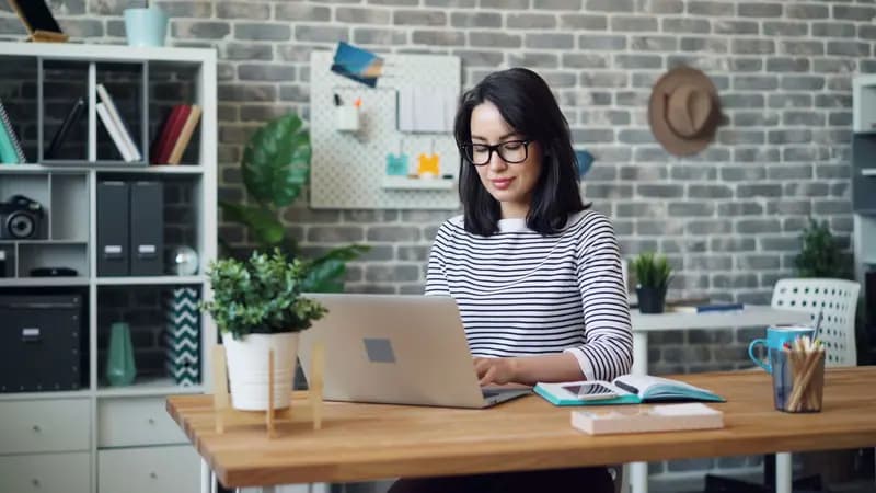 A woman sitting at a desk using a laptop