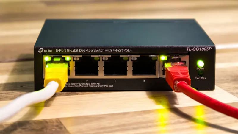 An ethernet switch with connected cables on a wooden surface