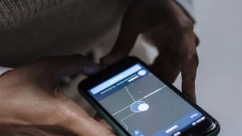 Woman holding a phone showing a parental control application screen
