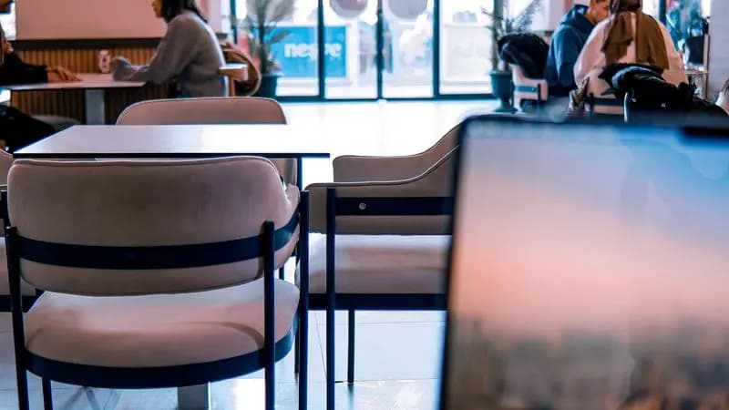 People working on laptops inside a modern cafe