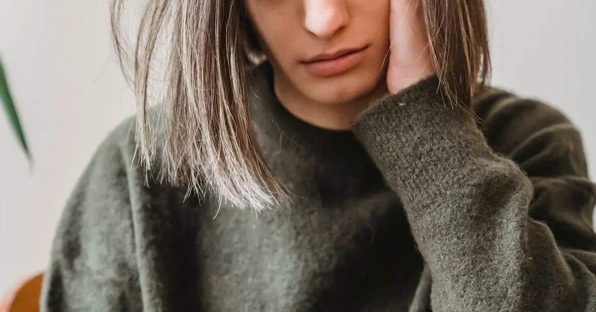 Woman looking concerned while reading her smartphone indoors