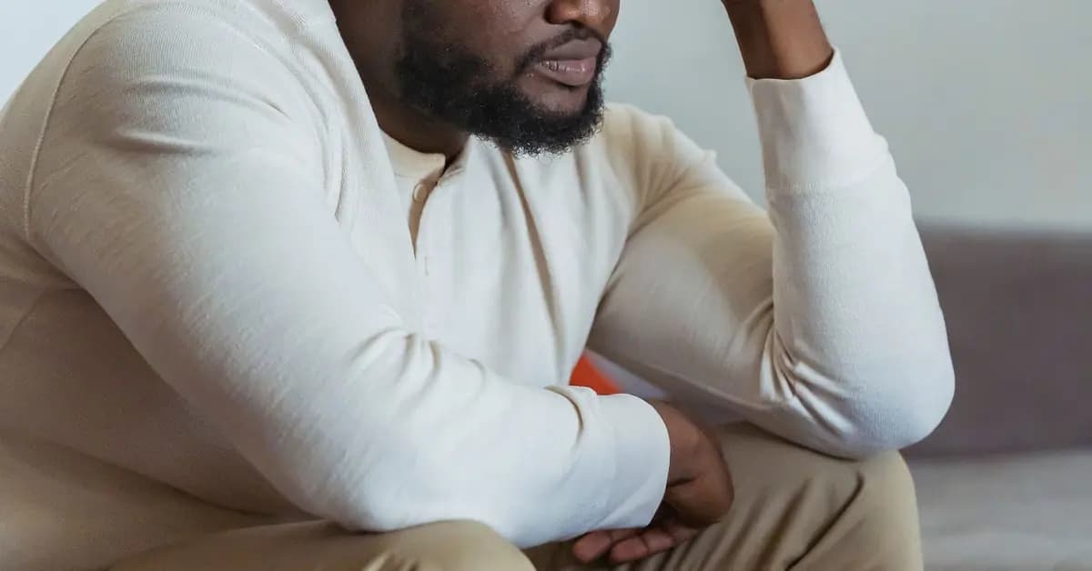 Man looking frustrated and concerned at a laptop in a home setting