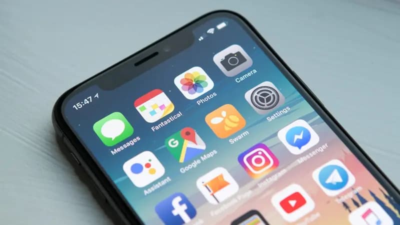 A close-up of an iPhone home screen full of apps