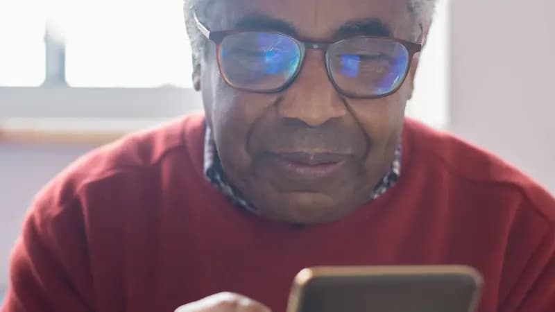 An older man looking at a smartphone