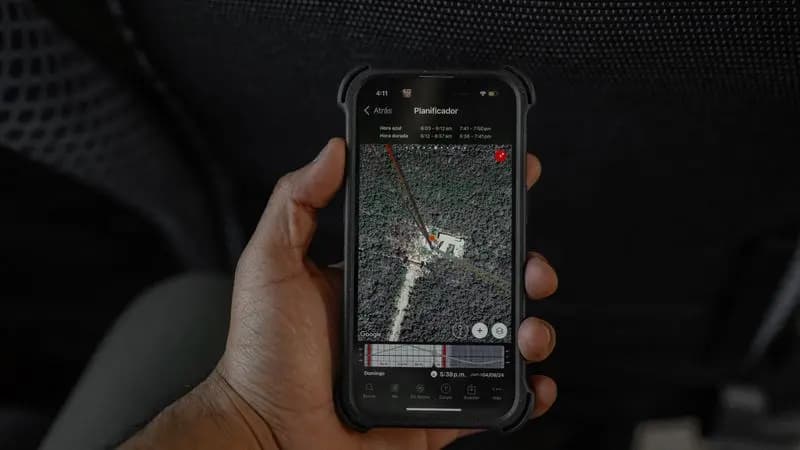 Hand holding a smartphone displaying a GPS map for device tracking
