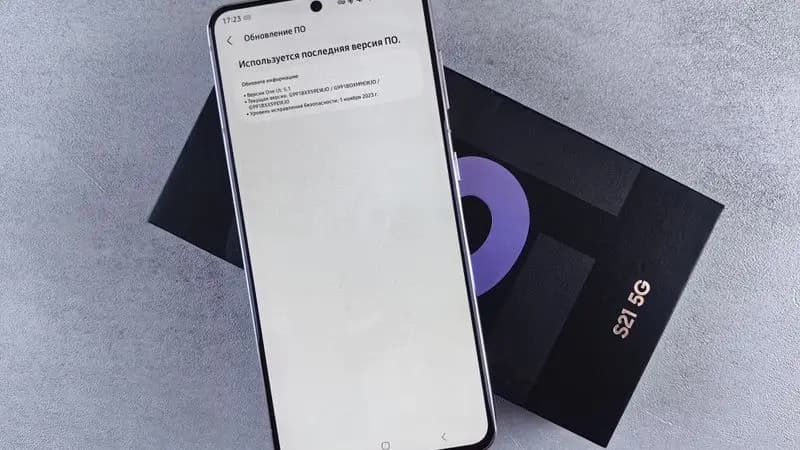 Samsung smartphone sitting on its box displaying a software update screen