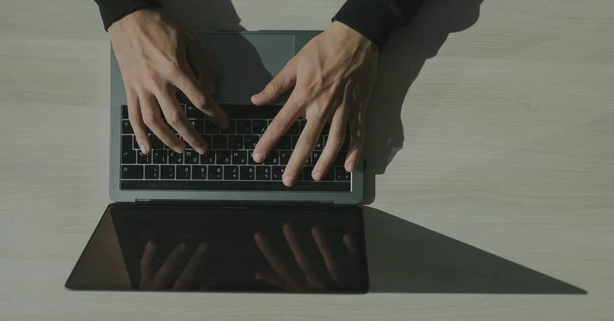 Overhead view of hands typing a password on a laptop keyboard