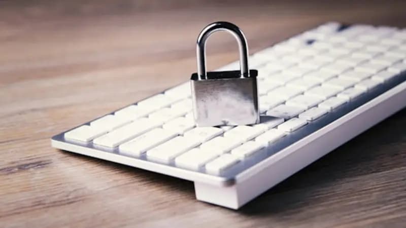 A metal padlock resting on a computer keyboard